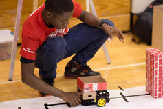 A high school student tests his robotic car.